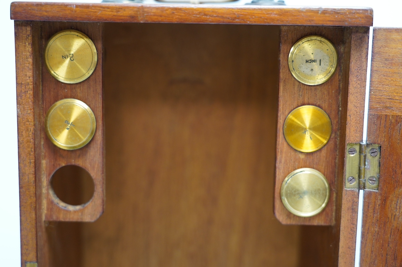 An unmarked late 19th century monocular brass microscope, in a fitted mahogany case with alternative lenses, a drawer for slides and other accessories, case 39cm high. Condition - fair to good